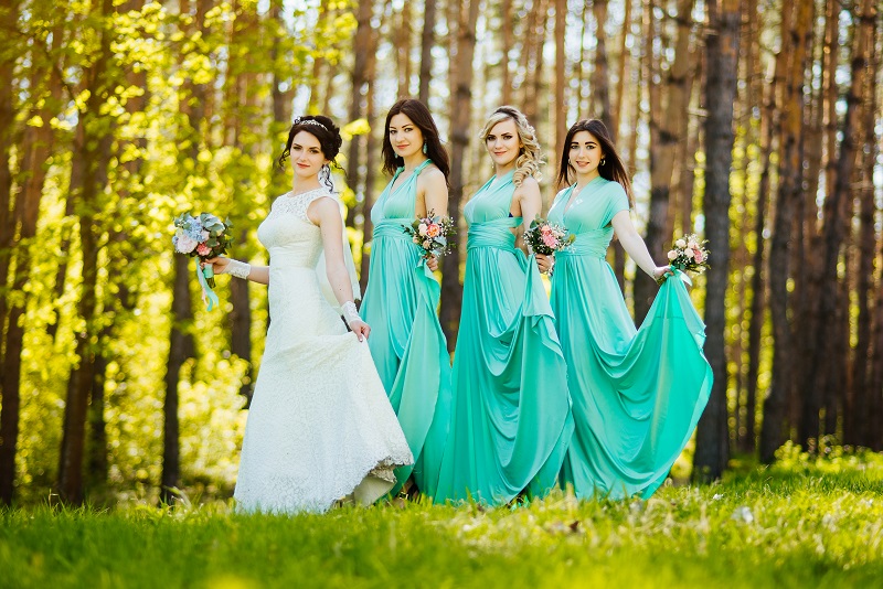 Bridesmaids in assorted pastel dresses of peach, mint, and lavender