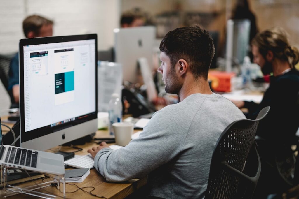 A man in an office researching knowledge management on his computer